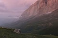 Amazing morning summer mountain landscape with high orange rocky cliff of canyon in soft mist of overcast blue sky Royalty Free Stock Photo