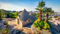 Amazing morning view of strret with trullo trulli - traditional Apulian dry stone hut with a conical roof. Impressive spring ci