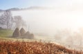 Amazing mountain landscape with fog and a haystack in autumn Royalty Free Stock Photo