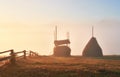 Amazing mountain landscape with fog and a haystack in autumn Royalty Free Stock Photo