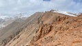 Amazing mountain landscape. Panorama of red rocky cliffs and snow-capped mountains. Blue sky and white clouds. The amazing nature Royalty Free Stock Photo