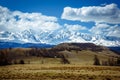 Amazing mountain landscape. Rocky mountains with snowy peaks, hills covered with grass in the Alpine scene on a bright sunny day Royalty Free Stock Photo