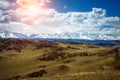 Amazing mountain landscape. Rocky mountains with snowy peaks, hills covered with grass in the Alpine scene on a bright sunny day Royalty Free Stock Photo