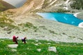 Amazing mountain sunny landscape with blue lake and two tourists