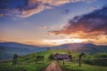 Amazing mountain view. wooden fence, rural road and high mountain village on sunset. summer landscape.  natural Royalty Free Stock Photo