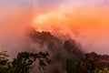 Amazing natural landscape with stone pillars quartz mountains in fog and clouds during amazing sunset, Zhangjiajie National park. Royalty Free Stock Photo