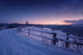 Amazing nature mountains landscape, winter path at night with snow and beautiful blue sky with stars and glow of sunset Royalty Free Stock Photo