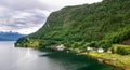 Amazing nature view with dramatic sky and wooden houses on the banks of the Norwegian fjord. Scandinavian Mountains, Norway. Royalty Free Stock Photo