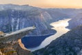 Amazing nature view with Trolltunga and a man sitting on it at sunset under the moon. Location: Scandinavian mountains, Norway, Od Royalty Free Stock Photo