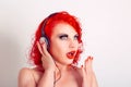 Amazing news on radio. Amazed cheerful beautiful redhead woman, listening music with black headphones