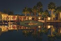 Amazing night view of tropical luxury hotel area with swimming pool, palm tree and beautiful night illuminations.