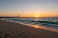 Amazing orange sunset at the beach in Dubai. Beautiful orange colors coming from sun and reflect over Gulf sea waves and shore of Royalty Free Stock Photo