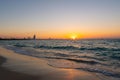 Amazing orange sunset at the beach in Dubai. Beautiful orange colors coming from sun and reflect over Gulf sea waves and shore of Royalty Free Stock Photo