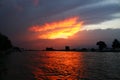 Amazing orange sunset between clouds over water