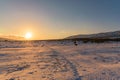 Amazing orange sunset in snow-covered field with footprints. Russia, Stary Krym. Royalty Free Stock Photo