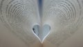 Pages of an open book curved into a heart shape inside with text in spanish Royalty Free Stock Photo