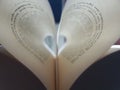 Pages of an open book curved into a heart shape inside with text in spanish Royalty Free Stock Photo