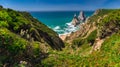 Amazing panorama of Rocky shore Atlantic Ocean. View of high cliffs, green hills, foamy waves and sandy beach. Sunny summer seasca Royalty Free Stock Photo