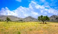Amazing panorama of rough wild mountains, grass, cloudy blue sky, Lasithi, Crete