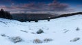 Amazing panoramic landscape  winter mountains at sunrise. View of dramatic overcast sky and distance snow capped peaks. Royalty Free Stock Photo