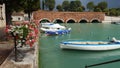 Amazing panoramic view of Peschiera del Garda, Italy. Sky before the rain, boats in the water near the bridge Royalty Free Stock Photo