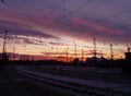 Amazing purple sunset over the railway station. Beautiful twilight evening sky. Track railroad in perspective Royalty Free Stock Photo