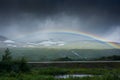 Amazing rainbow in cloudy sky over the tundra landscape on the Arctic Circle line in northern  Norway Royalty Free Stock Photo