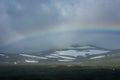 Amazing rainbow in cloudy sky over the tundra landscape on the Arctic Circle line in northern  Norway Royalty Free Stock Photo