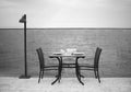 Amazing romantic dinner on the beach. Romance and love, dinning table setup with sea view in cloudy day. Black white photo