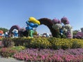 Amazing romantic walk in Miracle garden in Dubai, sidewalk between flowers, smurfs