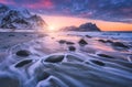 Amazing sandy beach with stones in blurred water at sunset