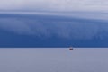 Seascape with large thunderstorm clouds above sea surface with tugboat