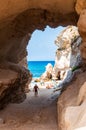 Amazing seascape view from unique sea cave on famous Rotonda beach. Tourists walking through the grotto, resting on small beach.