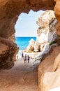 Amazing seascape view from unique sea cave on famous Rotonda beach. Tourists walking through the grotto, resting on small beach.