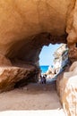 Amazing seascape view from unique sea cave on famous Rotonda beach. Tourists walking through the grotto, resting on small beach.