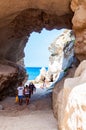 Amazing seascape view from unique sea cave on famous Rotonda beach. Tourists walking through the grotto, resting on small beach.