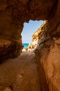 Amazing seascape view from unique sea cave on famous Rotonda beach. Tourists walking through the grotto, resting on small beach.