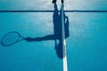 Amazing shot of a female shadow on a blue tennis court ground