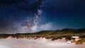 Amazing shot of a sandy landscape on a blue sky background full of stars