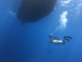 Amazing shot of a scuba diver ascending to a boat