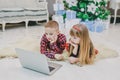 Amazing siblings buying christmas presents online with laptop together. Royalty Free Stock Photo