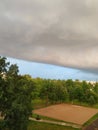 Amazing size huge thundercloud over the park with green trees. Before a rainstorm. Royalty Free Stock Photo