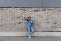 Amazing slim woman in blue jeans posing near brick wall in good spring day. Refined caucasian girl