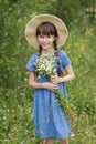 Amazing smiling girl in a hat with bouquet of flowers