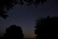 Amazing starry night sky with Milky way and falling stars above lake and trees in mountains. Beautiful night sky. Breathtaking Royalty Free Stock Photo