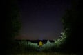 Amazing starry night sky with Milky way and person looking at stars above lake and trees in mountains. Beautiful night sky. Royalty Free Stock Photo