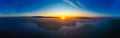 Amazing sun shines on horizon at dawn. Foggy aerial landscape. Blue sky in morning
