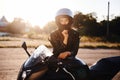 Amazing sunlight. Woman is with motorcycle outdoors