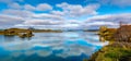 Amazing sunny day on lake Myvatn, Iceland, Europe. Beautiful clouds reflected in the blue water of a volcanic lake. Artistic Royalty Free Stock Photo