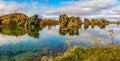 Amazing sunny day on lake Myvatn, Iceland, Europe. Volcanic rock formations reflected in the blue clear water of a volcanic lake. Royalty Free Stock Photo